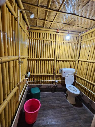 a bathroom with a toilet in a wooden cell at Dodo's Bamboo Resort in Rāja Māyang