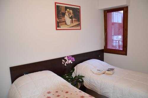 Un dormitorio con dos camas y un cuadro en la pared. en Le Sorgenti, en Bormio