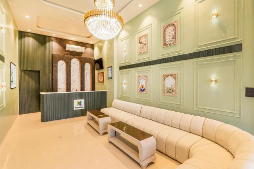a living room with a large couch and a chandelier at Treebo Sairadha in Pune