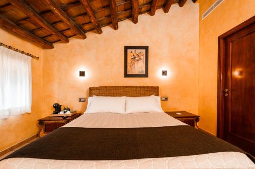 a bedroom with a large bed with two night stands at L'Agora Hotel in Bocairent