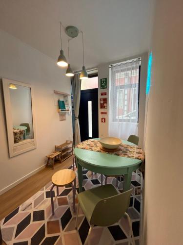 a dining room with a green table and chairs at Dolce Faro Niente Guest House in Faro