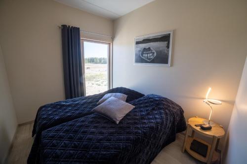 a bedroom with a bed and a lamp and a window at Marina Resort A9 in Kalajoki