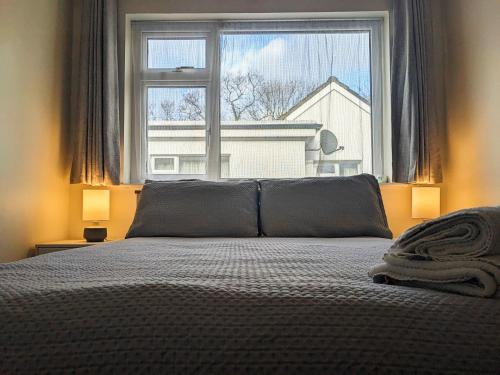 a bedroom with a bed and a large window at Dunloe View in Killarney