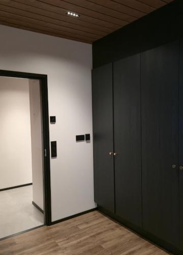 an empty room with black cabinets and a door at Metsolinna in Kittilä