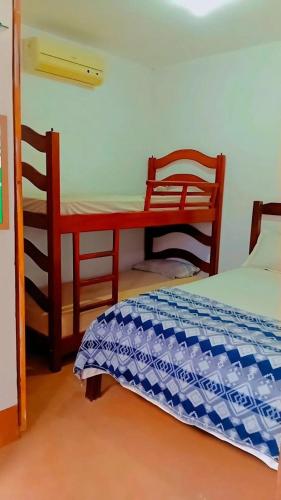 a bedroom with a bed and a desk and chairs at BELL MAR CHALÉs 03 in Luis Correia
