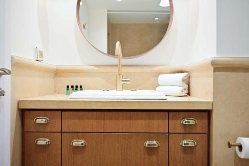 a bathroom with a sink and a mirror at (Floor Shelter)Luxury Sea View w/Pool Inside Hotel in Tel Aviv
