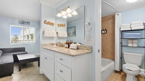 a bathroom with a sink and a toilet and a tub at Clearwater Beach Pelican 2 in Clearwater Beach