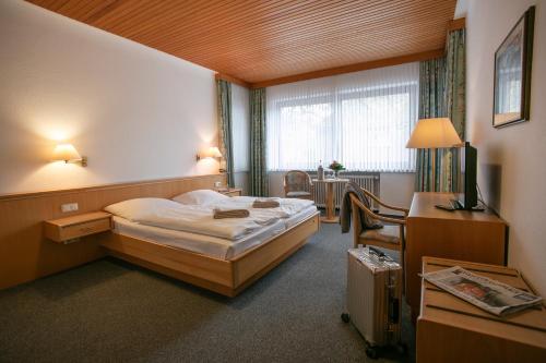 a hotel room with a bed and a desk at Klindworths Gasthof in Sauensiek