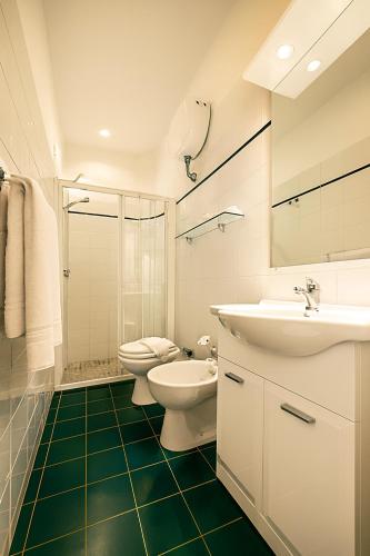 a bathroom with a toilet and a sink and a shower at Hotel Ariston in Piombino