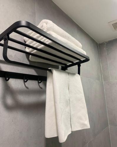 a towel rack in a bathroom with white towels at Zhejiang Pakxe Hotel in Pakse