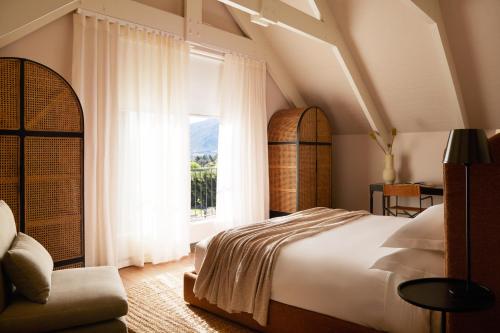 a bedroom with a large bed and a window at The Manor House at Colmant in Franschhoek