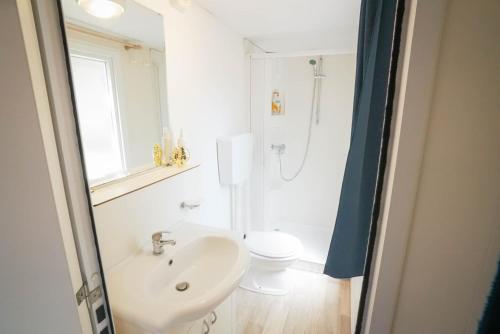 a white bathroom with a sink and a toilet at Camping Bella Austria - Maeva Vacansoleil in Sankt Peter am Kammersberg