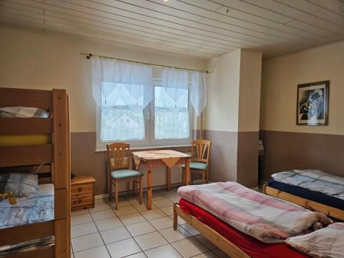 a room with two beds and a table and a window at Appartements & Ferienwohnungen Wolf in Usingen