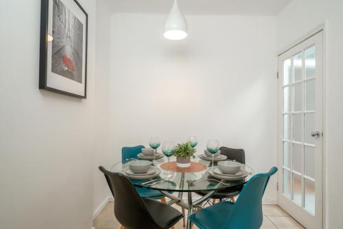 a dining room with a glass table and blue chairs at 5-Star 2BE Apt in Central London Perfect 2026 in London