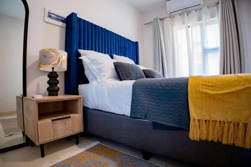 a bedroom with a blue bed and a window at Lerako Apartment in Gaborone