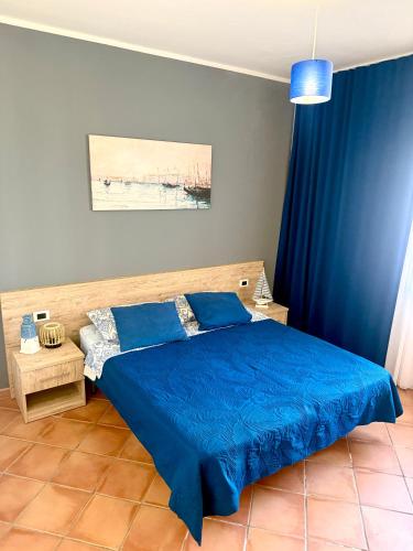 a bedroom with a blue bed and blue curtains at Marina Apartament in Scalea