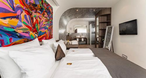 a bedroom with a large bed with a painting on the wall at PLAZA INN Bad Rappenau in Bad Rappenau