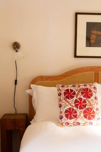 a bedroom with a bed with a pillow and a lamp at Sawmill Cottage in Acharacle