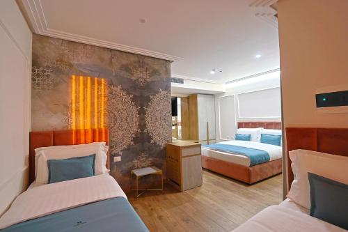 a bedroom with two beds and a wall at Martiness Hotel Durres in Durrës