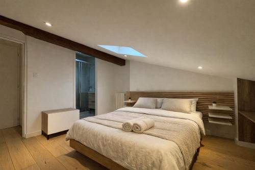 a bedroom with a large bed with a towel on it at Cocon Mansardé - Velux et Clim - Hyper Centre in Toulouse