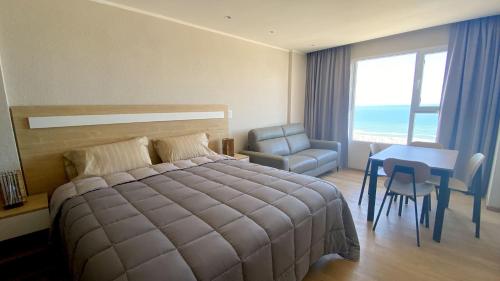 a bedroom with a bed and a table and a chair at Oceano in Necochea