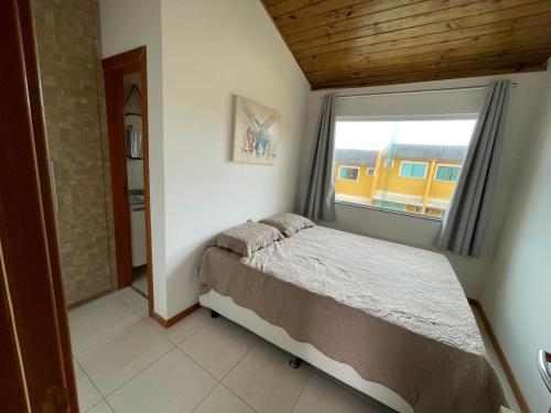 a bedroom with a bed and a large window at Casa summer flats 23 Imbassai in Imbassai