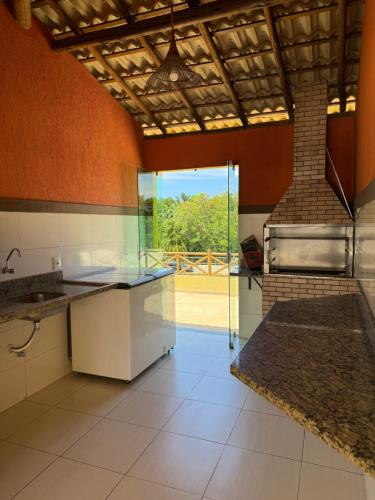 a large kitchen with a stove and a sink at Casa summer flats 23 Imbassai in Imbassai