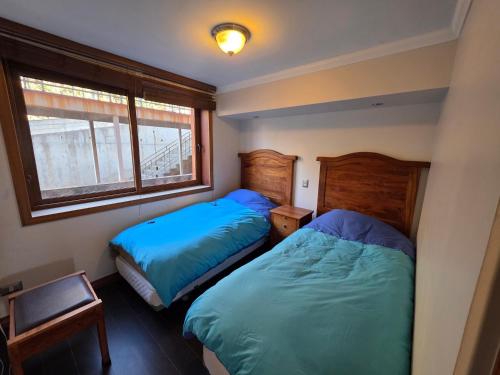 a bedroom with two beds and a window at Departamento Lago Vichuquen in Vichuquén Lake
