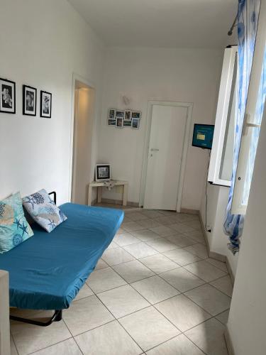 a bedroom with a blue bed and a tiled floor at Appartamentino Bianco in Rio Marina