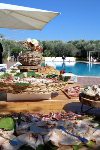a table with food on it next to a pool at La Meridiana in Lanuvio
