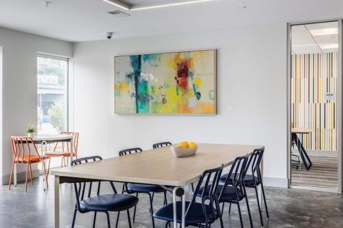 a dining room with a table and chairs and a painting at Modern apt in Cincy stadiums and with river views in Cincinnati