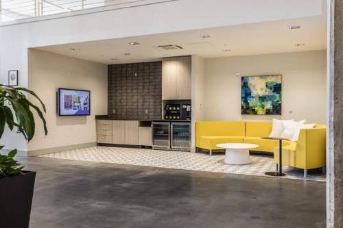 a kitchen with a yellow couch and a table at Modern apt in Cincy stadiums and with river views in Cincinnati