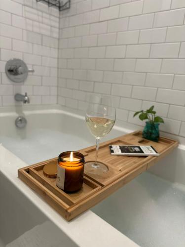 a candle and a wine glass on a tray in a bath tub at Modern apt in Cincy stadiums and with river views in Cincinnati