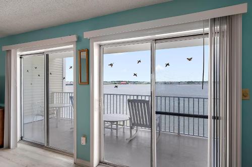 a room with sliding glass doors with a view of the water at Crab Cove 302 in Ocean City