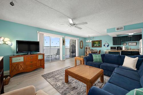 a living room with a blue couch and a tv at Crab Cove 302 in Ocean City