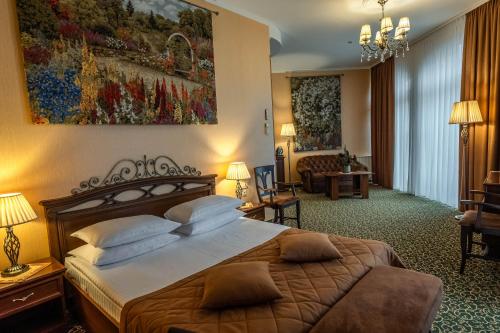 ein Hotelzimmer mit Bett und Wohnzimmer in der Unterkunft Premier Hotel Palazzo in Poltawa