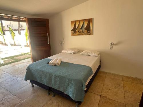a bedroom with a bed with two towels on it at BRKITE Pousada in Cumbuco