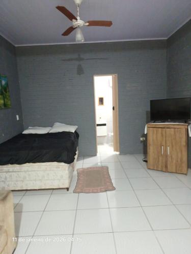 a bedroom with a bed and a ceiling fan at KitNet a caminho da ILHA DO MEL in Pontal do Paraná