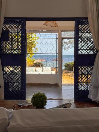 a room with a view of the ocean through a window at Attalah Beach Cottage in Mombasa