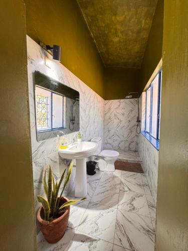 a bathroom with a sink and a toilet at Attalah Beach Cottage in Mombasa