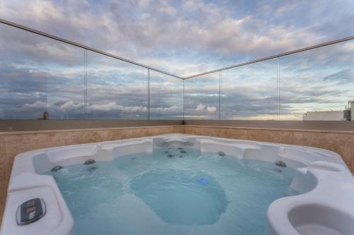 a hot tub on the roof of a building at NEW - Only Suites Unit 6 - Modern 2-Bedroom apartment with common heated Jacuzzi by SF Homes in St. Julianʼs