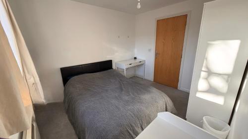 a bedroom with a bed and a wooden door at Double bedroom and private bathroom in the heart of Oxford in Oxford