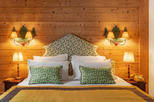 a bedroom with a bed with four pillows at Hôtel Saint-Georges Relais & Châteaux in Megève