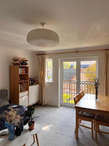 a living room with a table and a view of a balcony at Double bedroom and private bathroom in the heart of Oxford in Oxford