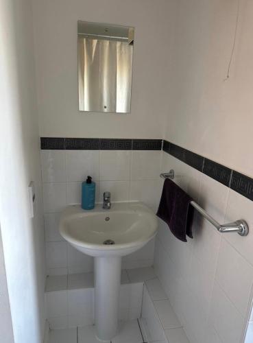 a white bathroom with a sink and a mirror at Double bedroom and private bathroom in the heart of Oxford in Oxford