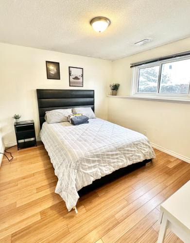 a bedroom with a bed and a wooden floor at Cozy & Private Full Floor at Minnow Lake in Sudbury
