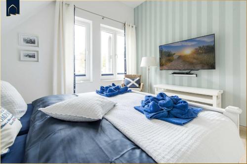 a bedroom with a bed with blue pillows on it at Kapitänsweg 12 in Karlshagen