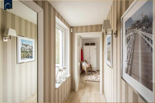 a hallway withbrown and white striped walls and a mirror at Kapitänsweg 12 in Karlshagen