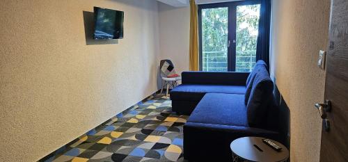 a living room with a blue couch and a window at Cabana Valea Lupilor in Straja