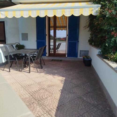 a patio with a table and chairs in front of a house at Casa Rossy in Pieve San Giacomo
